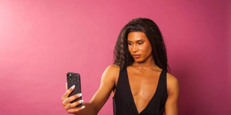 Transgender person looking at their phone, reading all about progesterone for gender-affirming care