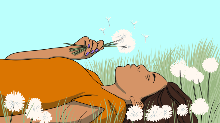 Woman laying in grass holding dandelion pappus