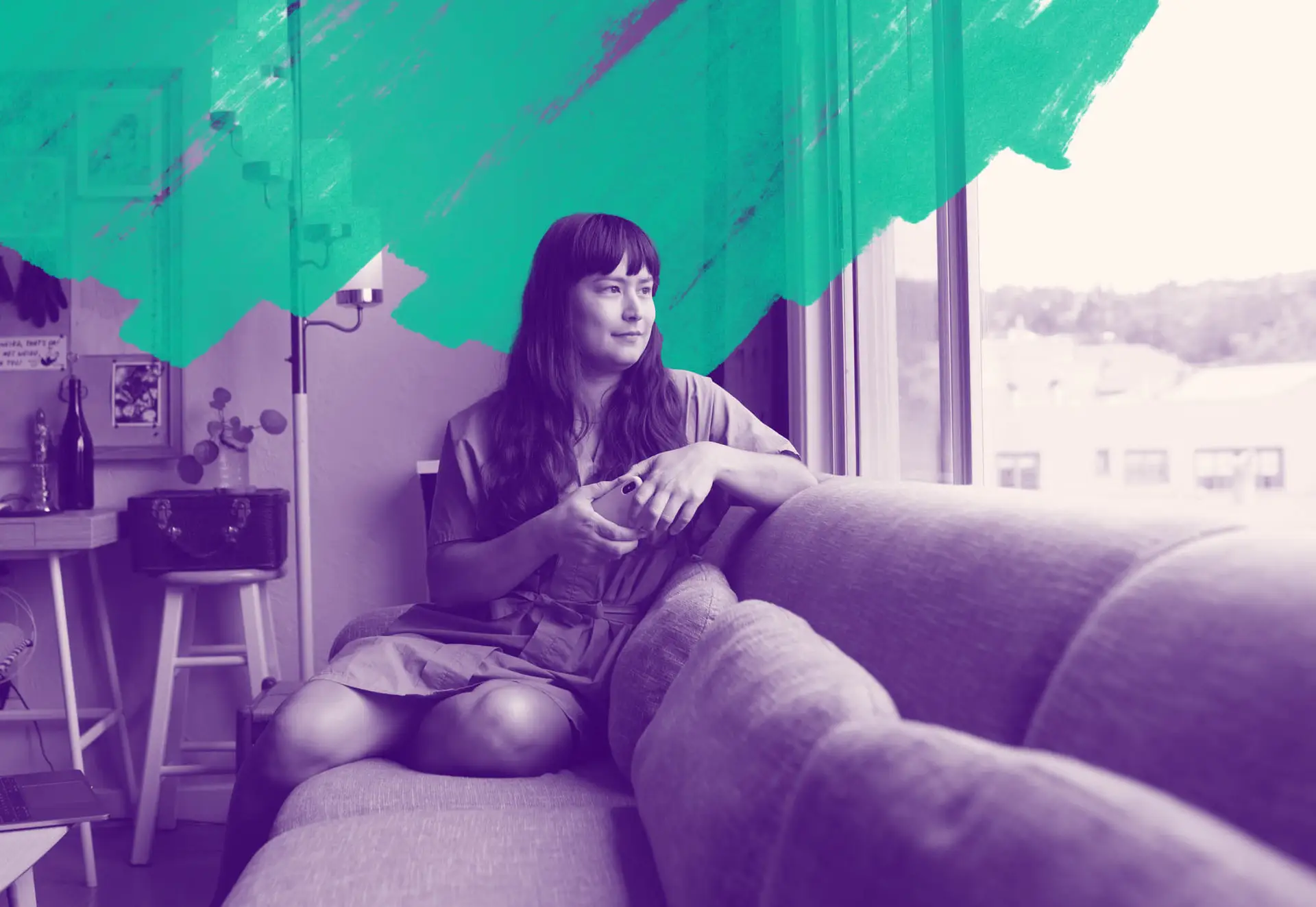 A transgender woman on a couch, focused and looking outside of the window, surrounded by a cozy environment.