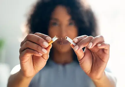 Xlose up of a person breaking a cigarette in half