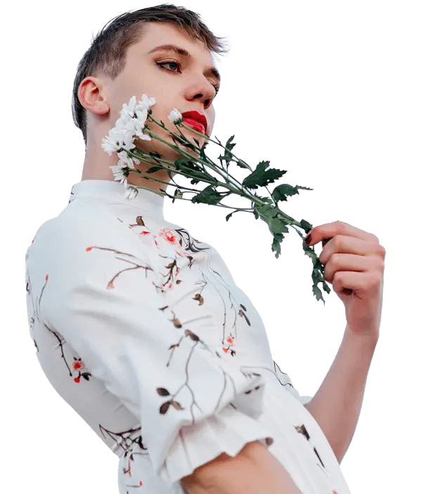Person in a white floral blouse holding daisies against a clear sky