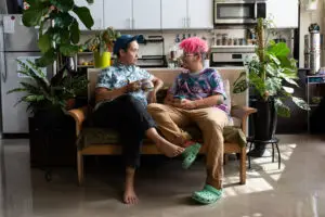 Two trans mascs people sitting on the couch. Cover photo for does testosterone make you gay?