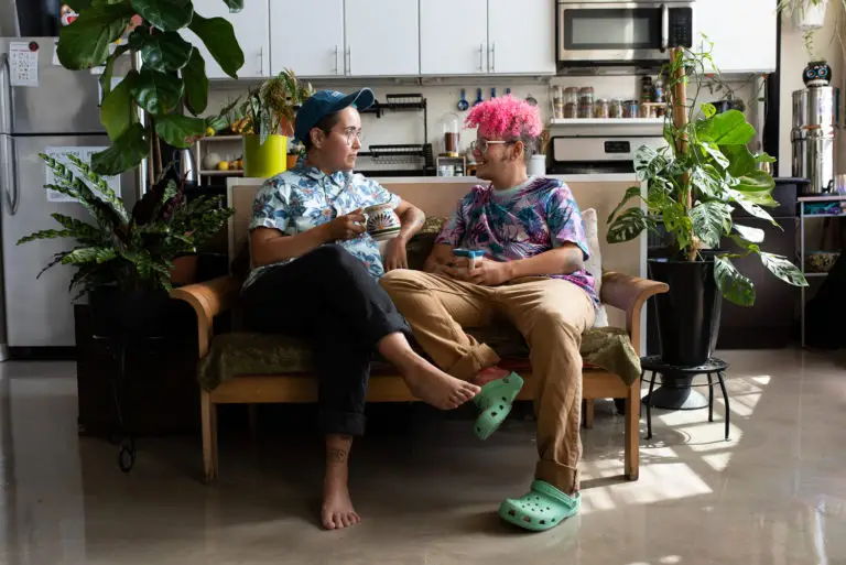 Two trans mascs people sitting on the couch. Cover photo for does testosterone make you gay?