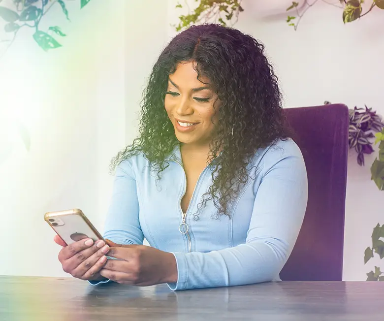 person looking at her smartphone smiling